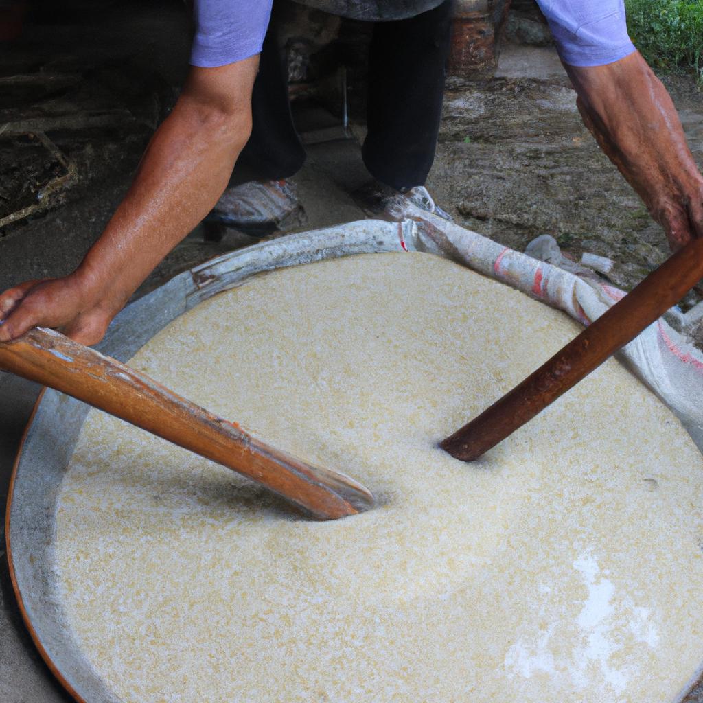 Person stirring rice fermentation process